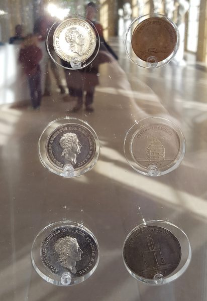 Szklane gabloty z monetami na wystawie w Starej Oranżerii